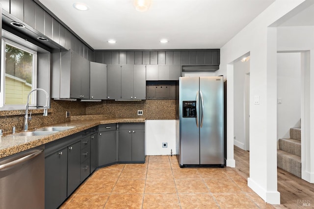 kitchen featuring backsplash, stainless steel appliances, gray cabinetry, and sink