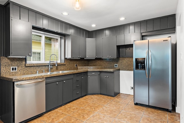 kitchen featuring backsplash, gray cabinets, sink, and stainless steel appliances