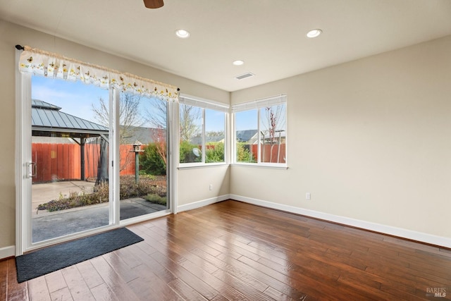 interior space with recessed lighting, wood-type flooring, visible vents, and baseboards