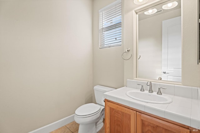 bathroom featuring tile patterned flooring, baseboards, vanity, and toilet