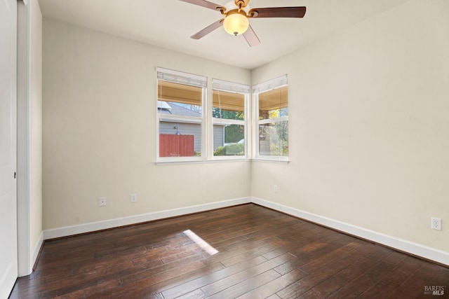 empty room featuring hardwood / wood-style flooring, baseboards, and a ceiling fan