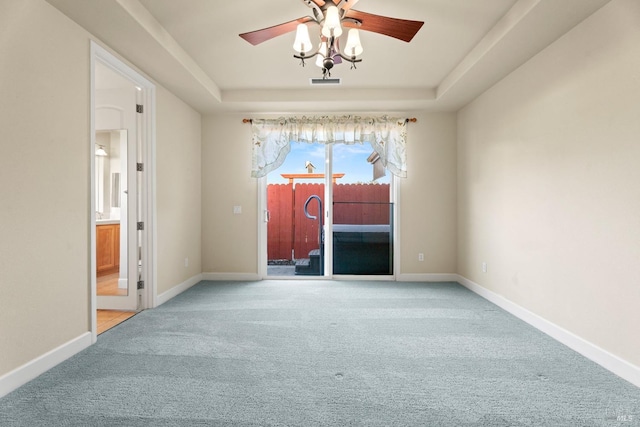 unfurnished room with carpet, a raised ceiling, visible vents, and baseboards