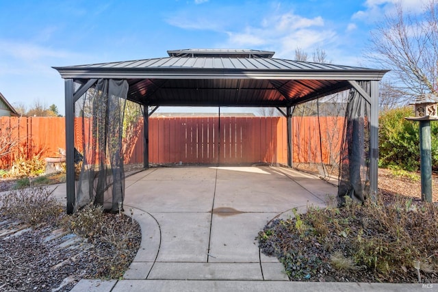 view of patio with a detached carport, fence, and a gazebo