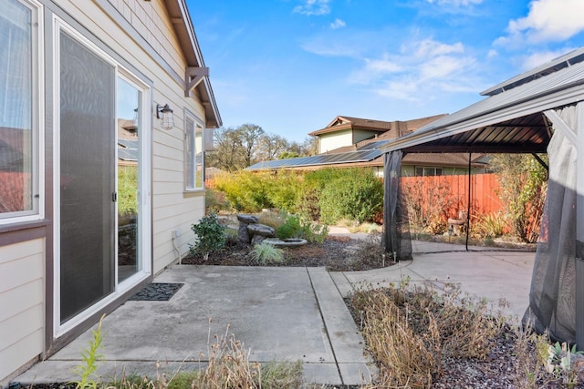 view of patio featuring fence and a gazebo