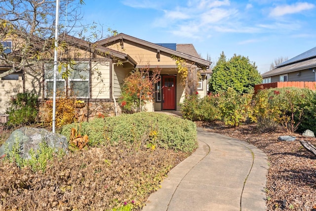 craftsman inspired home with stone siding and fence