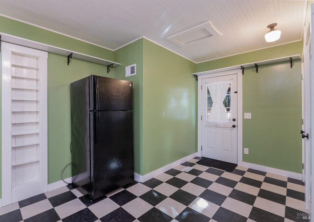 kitchen with crown molding and black refrigerator