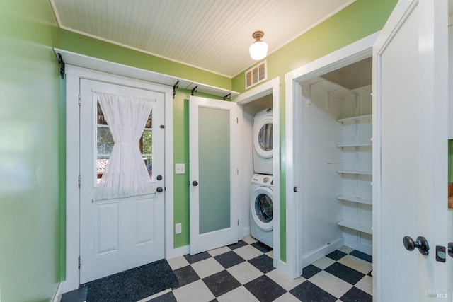 clothes washing area featuring stacked washing maching and dryer