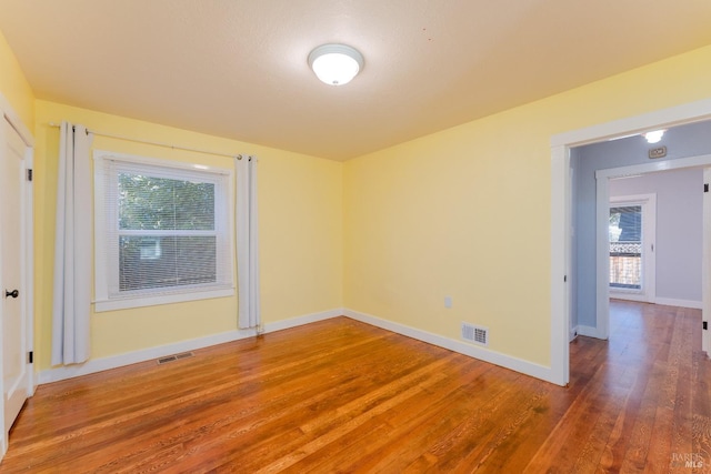 spare room with hardwood / wood-style flooring and a wealth of natural light