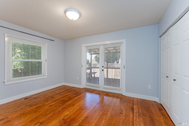 unfurnished room featuring french doors and hardwood / wood-style flooring