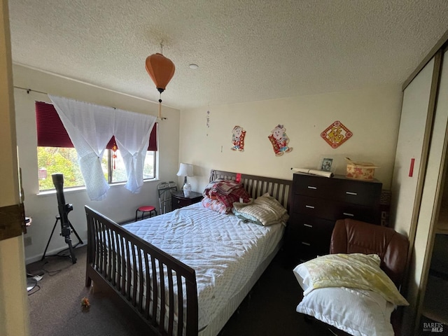 carpeted bedroom featuring a textured ceiling