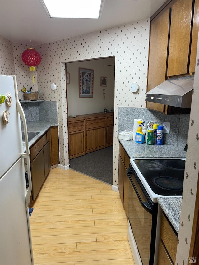 kitchen featuring black range with electric stovetop, light stone counters, light hardwood / wood-style flooring, range hood, and white refrigerator