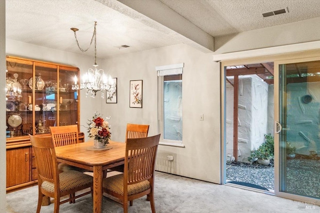 dining space with light colored carpet, a textured ceiling, and a notable chandelier