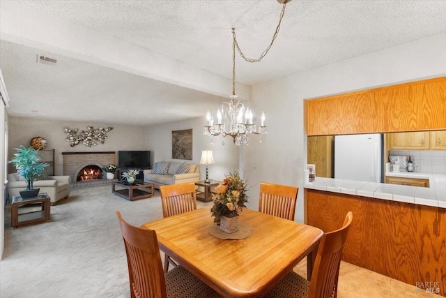 carpeted dining area featuring a textured ceiling and a chandelier