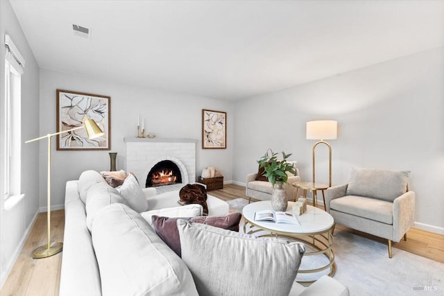 living room featuring a fireplace, wood finished floors, and baseboards