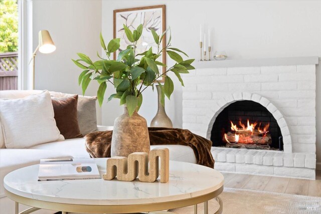 living room with carpet, a textured ceiling, and a brick fireplace