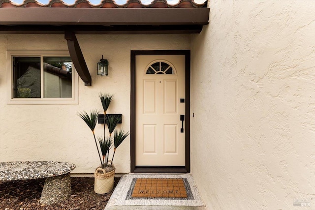 entrance to property featuring stucco siding