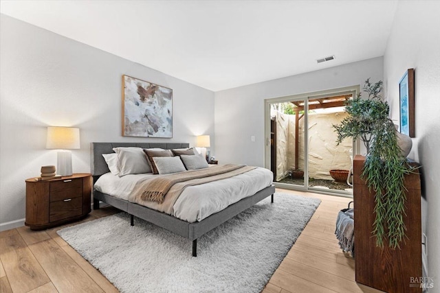 bedroom with access to exterior, light wood-type flooring, and visible vents