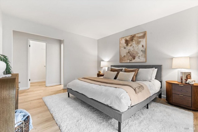 bedroom with baseboards and light wood-style floors