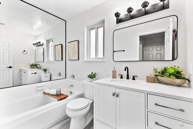 bathroom featuring vanity, a garden tub, and toilet