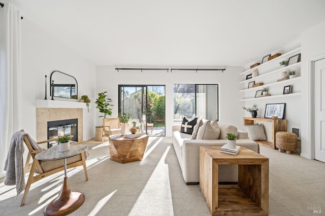 carpeted living room with a tiled fireplace