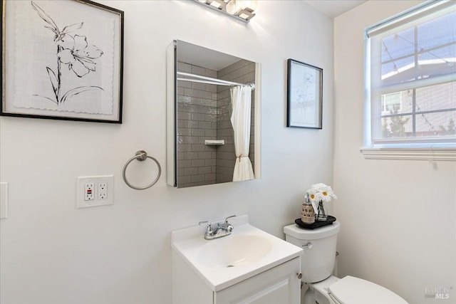 bathroom featuring a shower with curtain, vanity, and toilet