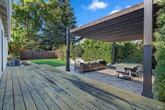 wooden deck featuring an outdoor living space, central AC unit, and a lawn