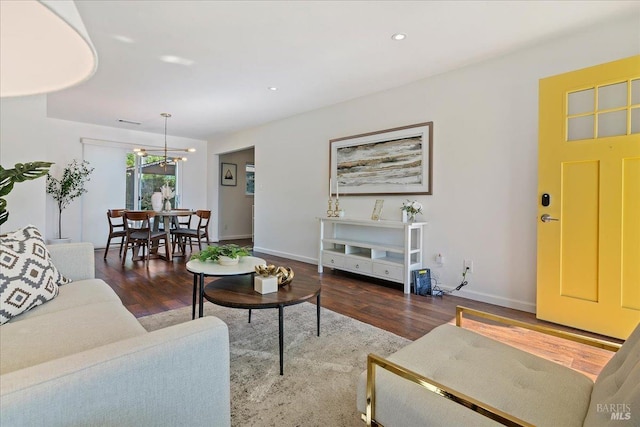 living room with hardwood / wood-style flooring and an inviting chandelier