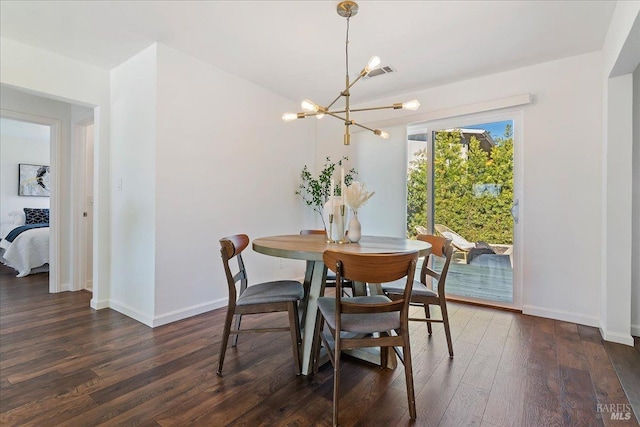 dining area with dark hardwood / wood-style flooring and an inviting chandelier