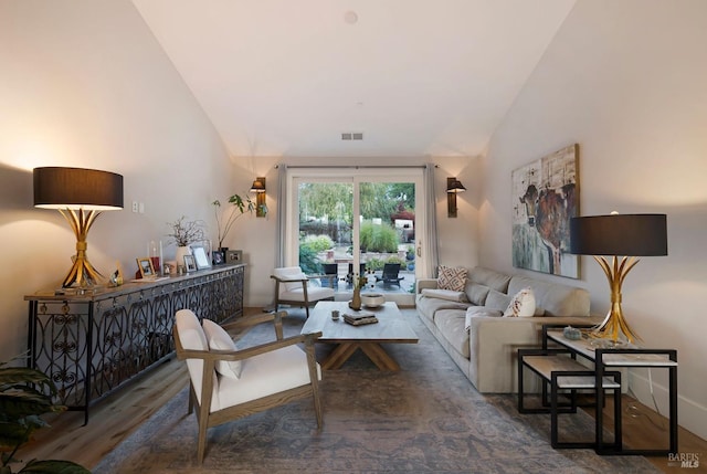 living area featuring wood finished floors, visible vents, and high vaulted ceiling