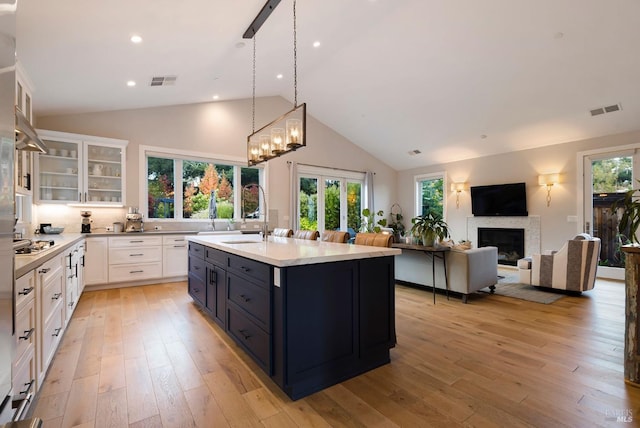 kitchen featuring white cabinetry, cooktop, a sink, and visible vents