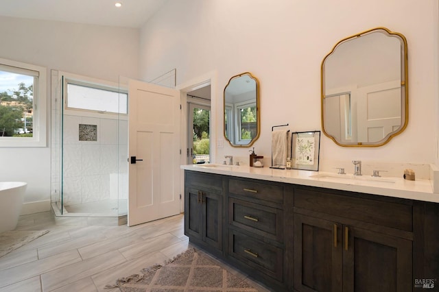 bathroom featuring a soaking tub, a sink, double vanity, recessed lighting, and a shower stall