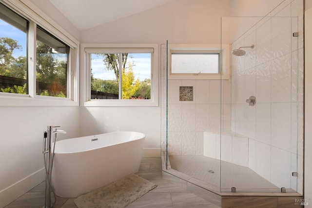 bathroom featuring a freestanding bath, lofted ceiling, and a stall shower
