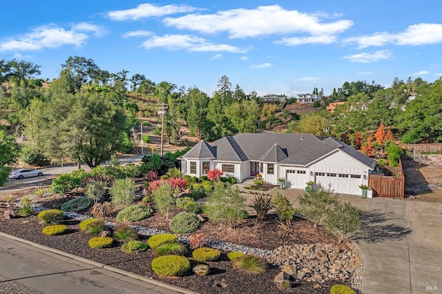 ranch-style house with concrete driveway, an attached garage, and fence
