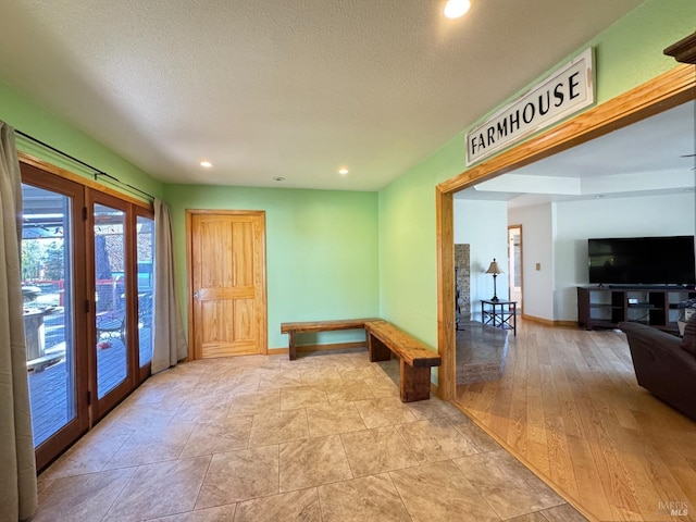 recreation room with a textured ceiling and light wood-type flooring