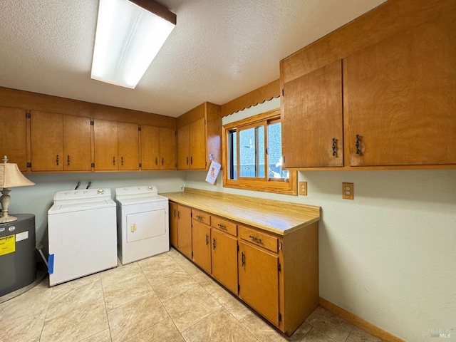 laundry area with cabinets, washer and dryer, light tile patterned floors, and a textured ceiling