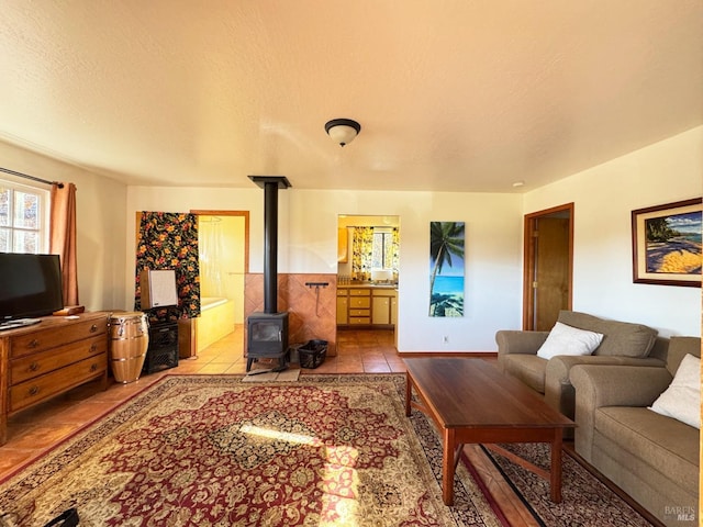 tiled living room with a textured ceiling and a wood stove