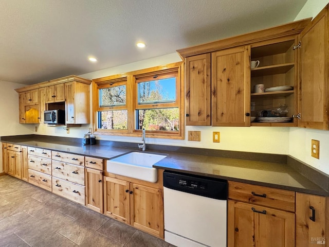 kitchen featuring dishwasher, sink, and a textured ceiling