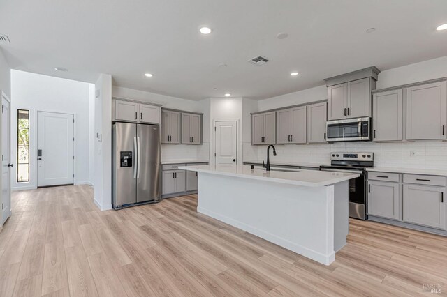 kitchen featuring light countertops, gray cabinetry, appliances with stainless steel finishes, and a sink