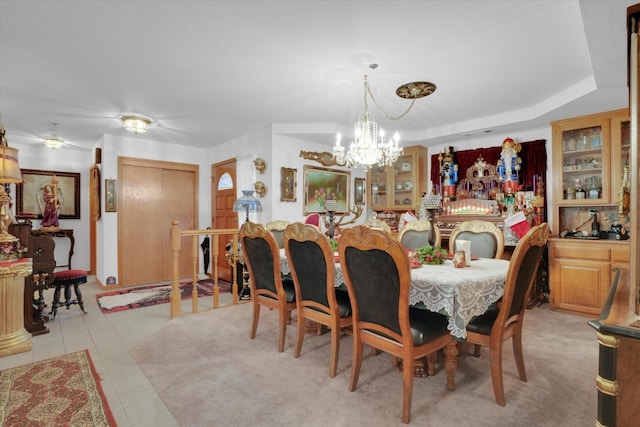 dining area with a chandelier, a tray ceiling, and light tile patterned flooring