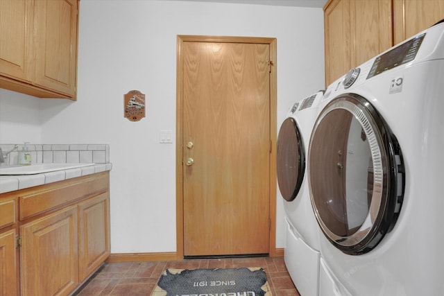 laundry area featuring cabinet space, baseboards, and washer and dryer