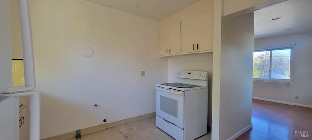 kitchen featuring white cabinets and white range with electric stovetop