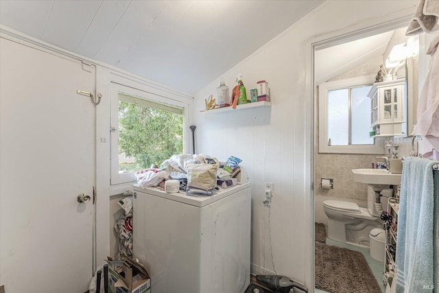 clothes washing area with tile walls and washer / clothes dryer