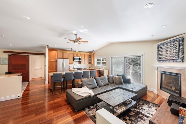 living room featuring lofted ceiling, ceiling fan, and dark wood-type flooring