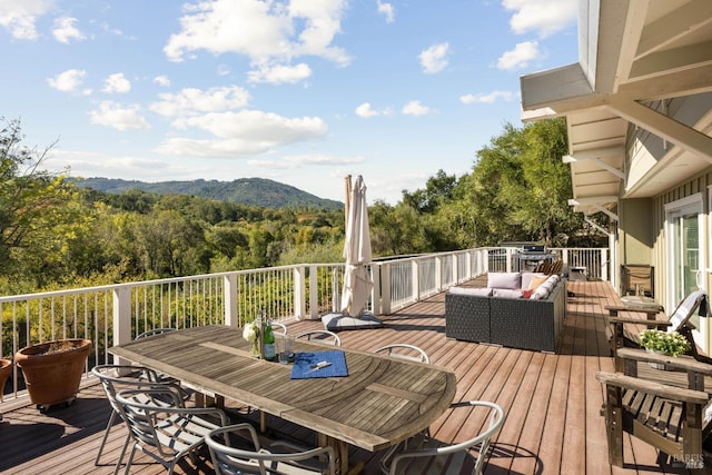 wooden deck featuring an outdoor living space and a mountain view