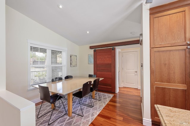 dining room with dark hardwood / wood-style flooring and vaulted ceiling