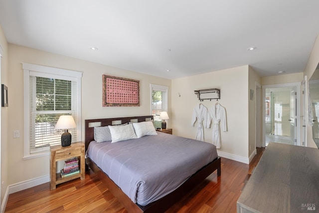 bedroom with hardwood / wood-style floors and ensuite bathroom