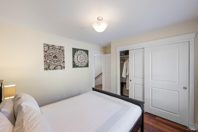 bedroom with dark hardwood / wood-style floors and a closet