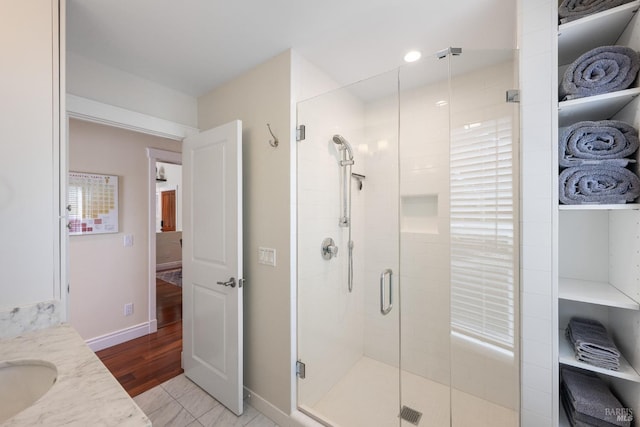 bathroom featuring vanity, an enclosed shower, and wood-type flooring