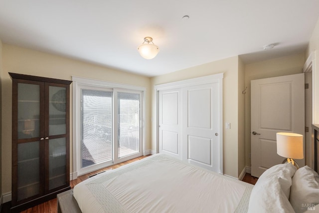 bedroom featuring dark wood-type flooring and access to outside