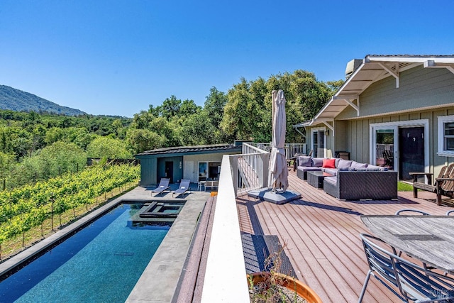 view of pool with an outdoor hangout area and a deck with mountain view